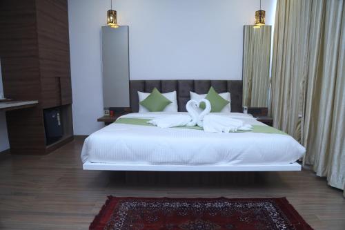 a bedroom with a white bed with a bow on it at Geetanjali International Annex a unit of Geetanjali International in Deoghar