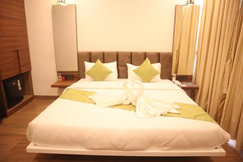 a bedroom with a bed with white towels on it at Geetanjali International Annex a unit of Geetanjali International in Deoghar