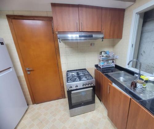 a small kitchen with a stove and a sink at ASDK Home 908-14 in Dubai