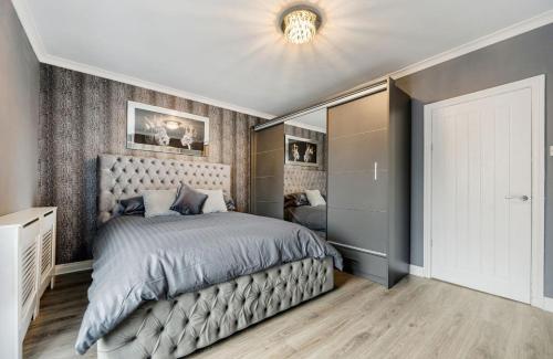 a bedroom with a large bed and a ceiling at Comfortable Cottage in Greater Manchester in Glazebury
