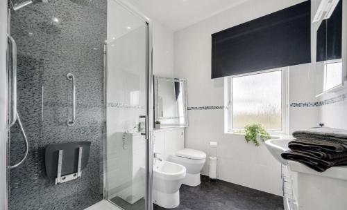 a bathroom with a shower and a toilet and a sink at Comfortable Cottage in Greater Manchester in Glazebury