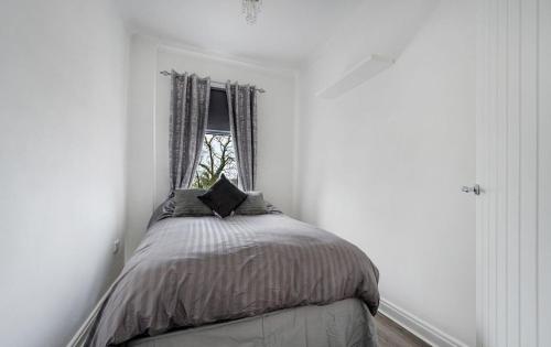 a bed in a white room with a window at Comfortable Cottage in Greater Manchester in Glazebury