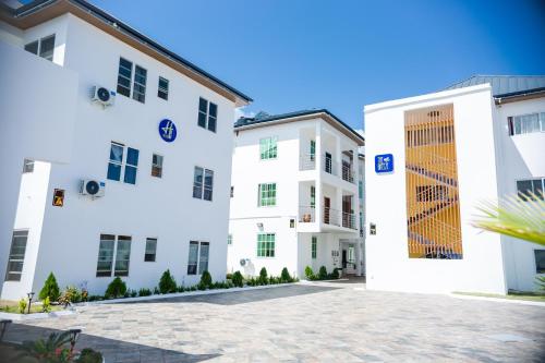 two white buildings with a door in the middle at Escape to Luxury, HVillage in Dawhwenya