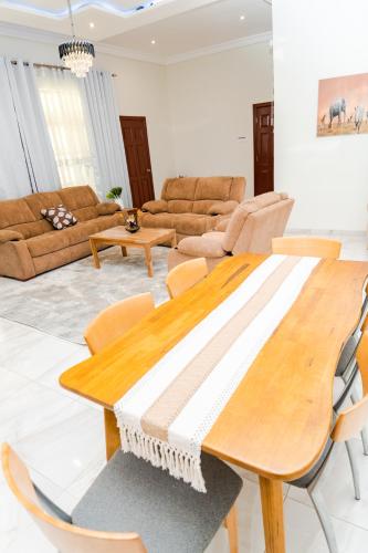 a living room with a wooden table and chairs at Escape to Luxury, HVillage in Dawhwenya