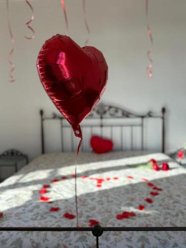 un ballon en forme de cœur rouge vole au-dessus d'un lit dans l'établissement LaVillaB Le domaine de la bastide, à Marseille