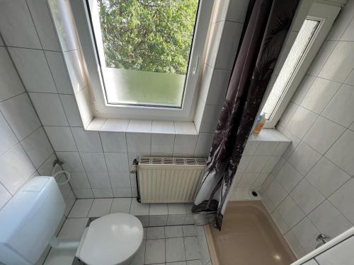 a bathroom with a toilet and a window at Wohnung mit Balkon am Rhein in Düsseldorf