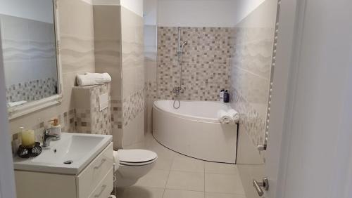 a white bathroom with a toilet and a sink at Zen Apartment in Bacău