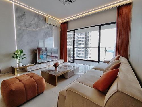 a living room with a couch and a tv at Astonishing Ocean View 3 Bedroom Apartment in Johor Bahru