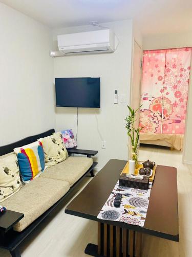 a living room with a couch and a table at Sakura桜ノ宮ヴィラ in Osaka