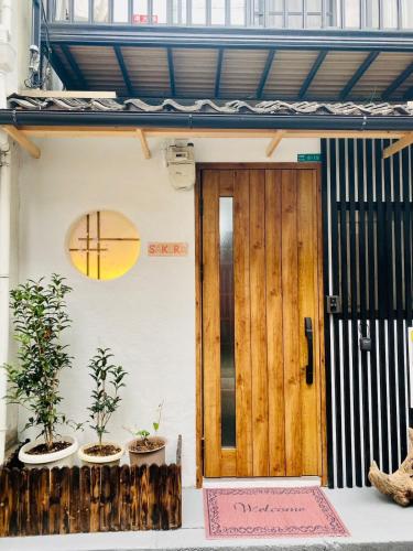 a door of a house with two potted plants at Sakura桜ノ宮ヴィラ in Osaka