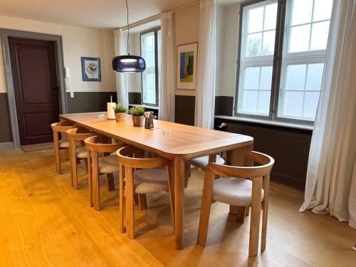 a wooden table and chairs in a room with windows at Copenhagen Collection King s Garden Studio in Copenhagen