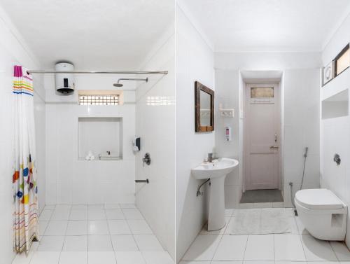 a white bathroom with a toilet and a sink at Storica Stays Panorama Haveli Udaipur in Udaipur
