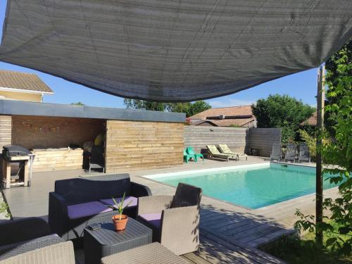 une arrière-cour avec une piscine et un parasol dans l'établissement Villa Côte d'Argent, à Moliets-et-Maa