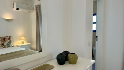 zwei Vasen auf einem Tisch vor einem Spiegel in der Unterkunft Jardim da Oura 2 by Check-in Portugal in Albufeira