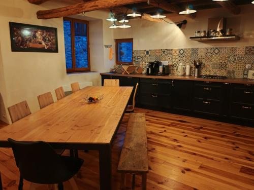 - une table en bois dans la cuisine dotée de parquet dans l'établissement Maison de village de caractère, 10 pers, à Beauvezer