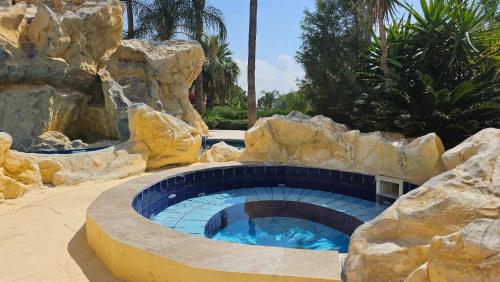 a large swimming pool in a fake rock formation at Mediterranean Sunrise Apartments A2 in Voroklini