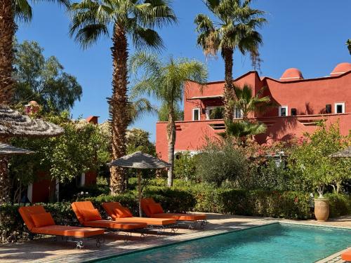a resort with a pool and chairs and palm trees at Le Palais Mandarine in Taroudant