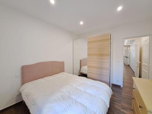 - une chambre avec un grand lit blanc et un placard dans l'établissement Orlando - Cocon Haussmanien en centre-ville, à Reims