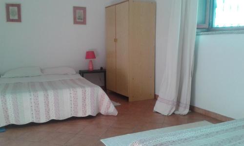 Un dormitorio con una cama y una cómoda y una ventana. en Su Furriadroxu Tuerredda, en Teulada