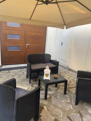 a patio with chairs and a table and an umbrella at LA MAISON aeroporto ciampino in Ciampino