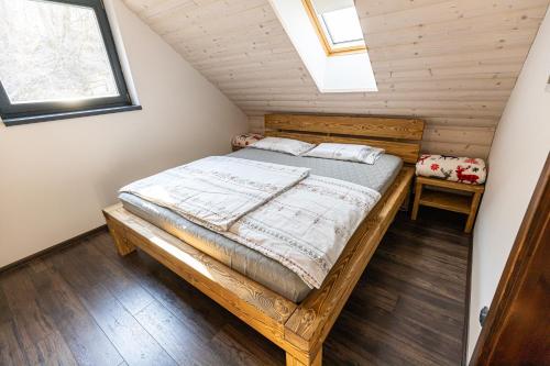 a bedroom with a wooden bed in a attic at Ozónia Wellness House in Šahy