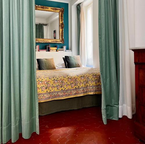 - une chambre avec un lit doté de rideaux verts et d'un miroir dans l'établissement Studio Olive, à La Ciotat