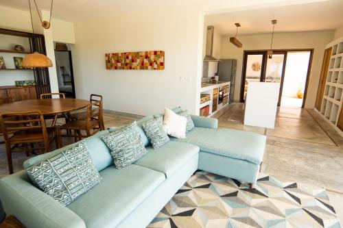 a living room with a blue couch and a table at Duna Sonambula in Praia do Tofo