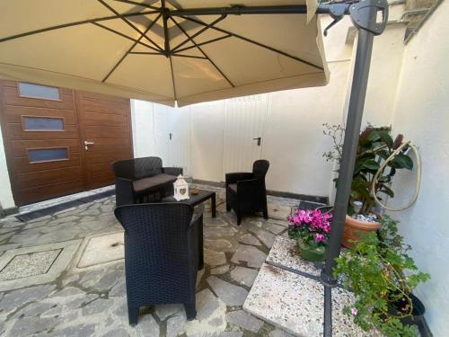 a patio with an umbrella and chairs and a table at LA MAISON aeroporto ciampino in Ciampino