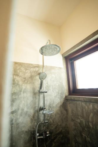 a shower in a bathroom with a shower head at Duna Sonambula in Praia do Tofo