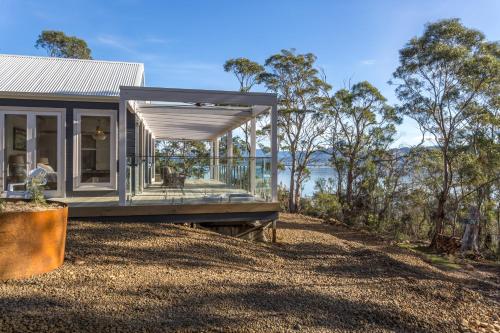a tiny house with a deck and a view of the water at The BoatHouse in Dover