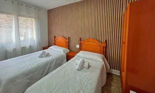 a bedroom with two beds and a window at Apartamentos Turísticos Cardelemin in Caminomorisco
