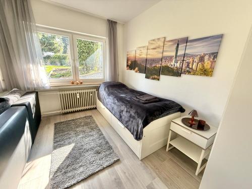 a small bedroom with a bed and a window at Gemütliches Apartment mit Blick ins Grüne nähe Messe in Meerbusch