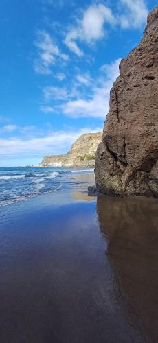 a beach with rocks and the ocean and the water at Vista Taurito Apartament in Taurito