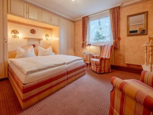 a hotel room with a bed and a chair at Hotel Wiesbaden in Wenningstedt