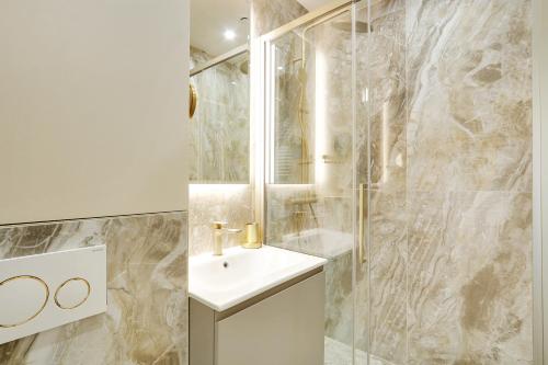 une salle de bain blanche avec un lavabo et une douche dans l'établissement Pick A Flat's Apartment in Invalides - Avenue de Breteuil, à Paris