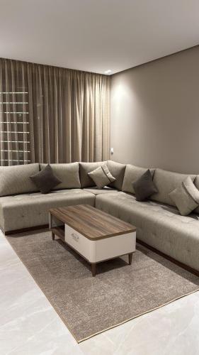 a living room with a large couch and a coffee table at Sky View Malabata Family only in Tangier