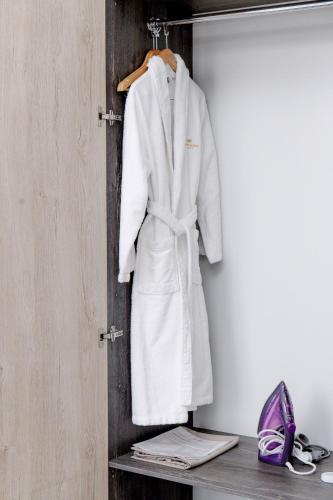 a white robe is hanging on a wall at Infinity Plaza Hotel in Atyraū