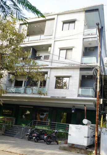 two motorcycles parked in front of a white building at STAY10 Apartment Hotel in Indore