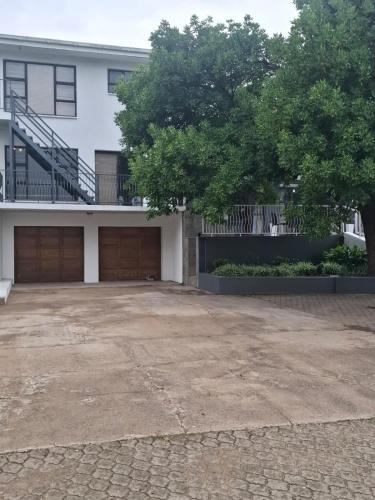 a large white house with two garage doors at Skylight Guest House in Harrismith