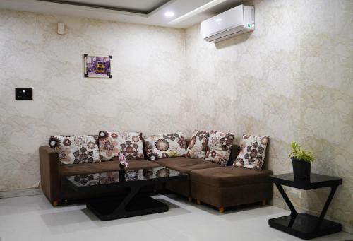 a living room with a brown couch in a room at STAY10 Apartment Hotel in Indore