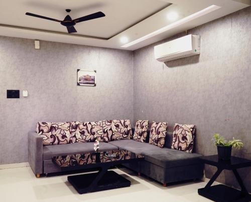 a living room with a couch and a ceiling fan at STAY10 Apartment Hotel in Indore