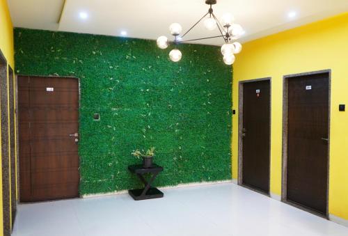 a green wall in a room with two doors at STAY10 Apartment Hotel in Indore