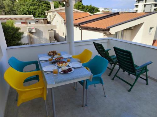 un tavolo e delle sedie su un balcone con del cibo sopra di Dzenan apartmani a Dobra Voda