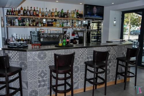 a bar with black bar stools in a room at Le Matisse Pau Centre in Pau