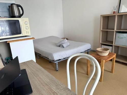 Cette petite chambre comprend un lit et un four micro-ondes. dans l'établissement ღ Le Funny - Studio Proche Plage & Parking gratuit, à La Rochelle