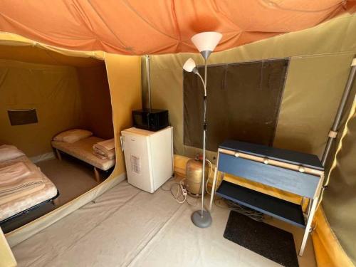 a small tent with a refrigerator and a lamp in it at Chalet 3 étoiles - eeiid0 in Matour