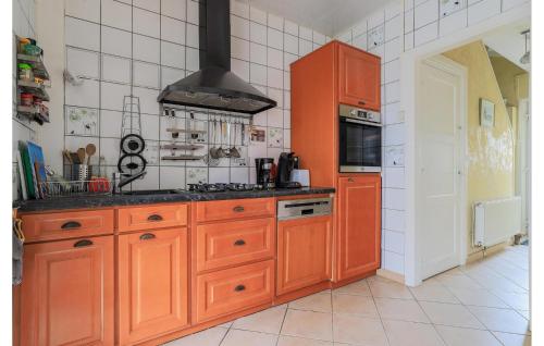 - une cuisine avec des armoires orange et une cuisinière dans l'établissement 2 Bedroom Cozy Home In Gravelines, à Gravelines