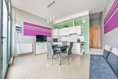 ミエンジズドロイェにあるMiędzyzdrojski Rynek by Baltic Homeのテーブルと椅子のあるキッチンとダイニングルーム