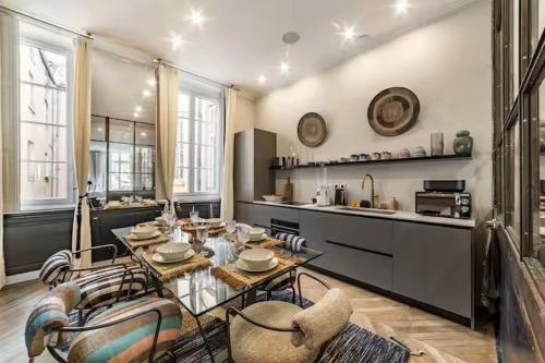 un salon avec une table et une cuisine dans l'établissement Le Petit Prince - T3 de Grand Standing au Vieux Lyon - Sauna, à Lyon