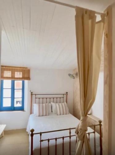 une chambre avec un lit et une fenêtre dans l'établissement Gîtes La Maison près de la fontaine et La Cabane du Pêcheur, à Talairan